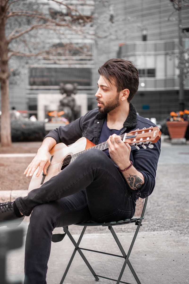 Adam Oturan Akustik Gitarist